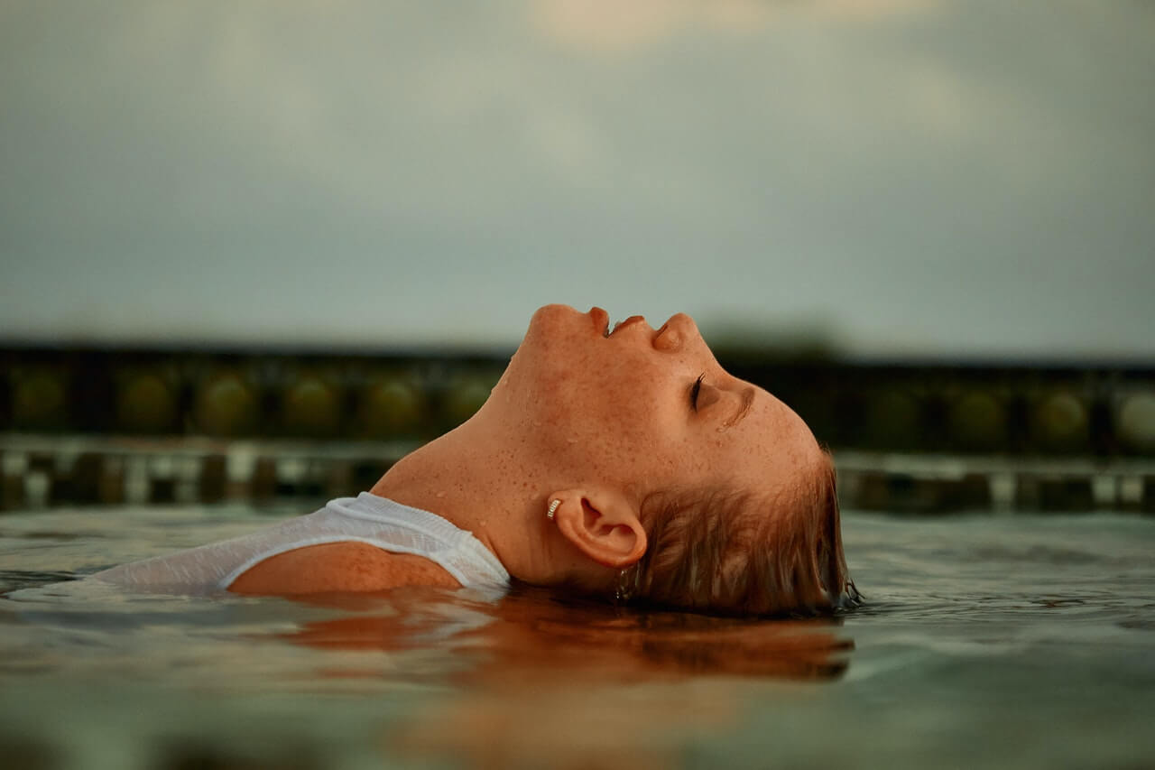 A woman relaxing in a cold outdoor pool
