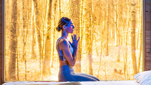 Woman meditating with winter forest background