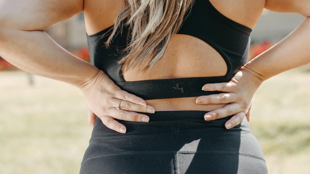 Woman touching her lower back muscles