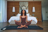 Woman Sitting On Mat Meditating