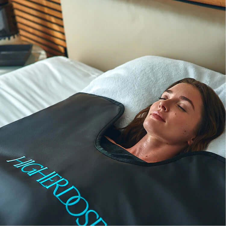 A woman relaxing in a HigherDOSE Infrared Sauna Blanket