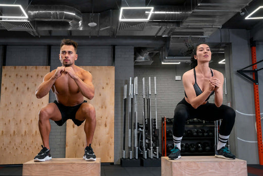 A shirtless, muscled man lifting a barbell with his left hand