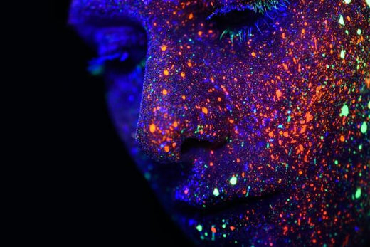 Close up photo of a female face with assorted colored lights.