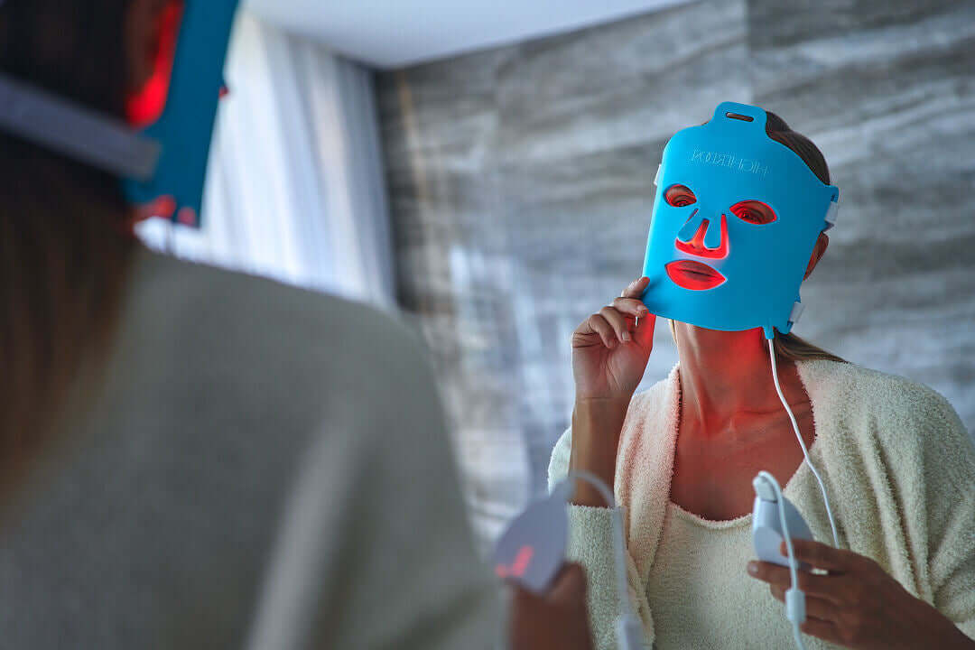 Woman going through red light therapy with a HigherDOSE Red Light Face Mask