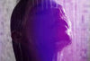 Lady taking a shower showing only her head with a neon violet background