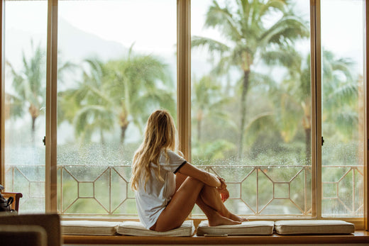 Photo of a woman sitting near the glass window.