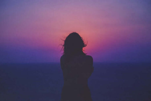 Photo of a woman watching the sunset.