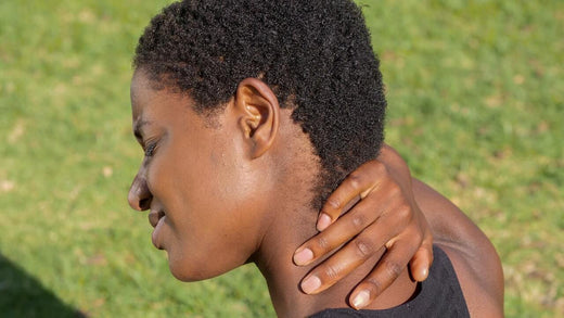 Woman grimacing and holding her painful neck with her right hand