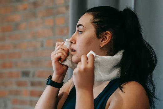 Woman wiping her face with a white towel