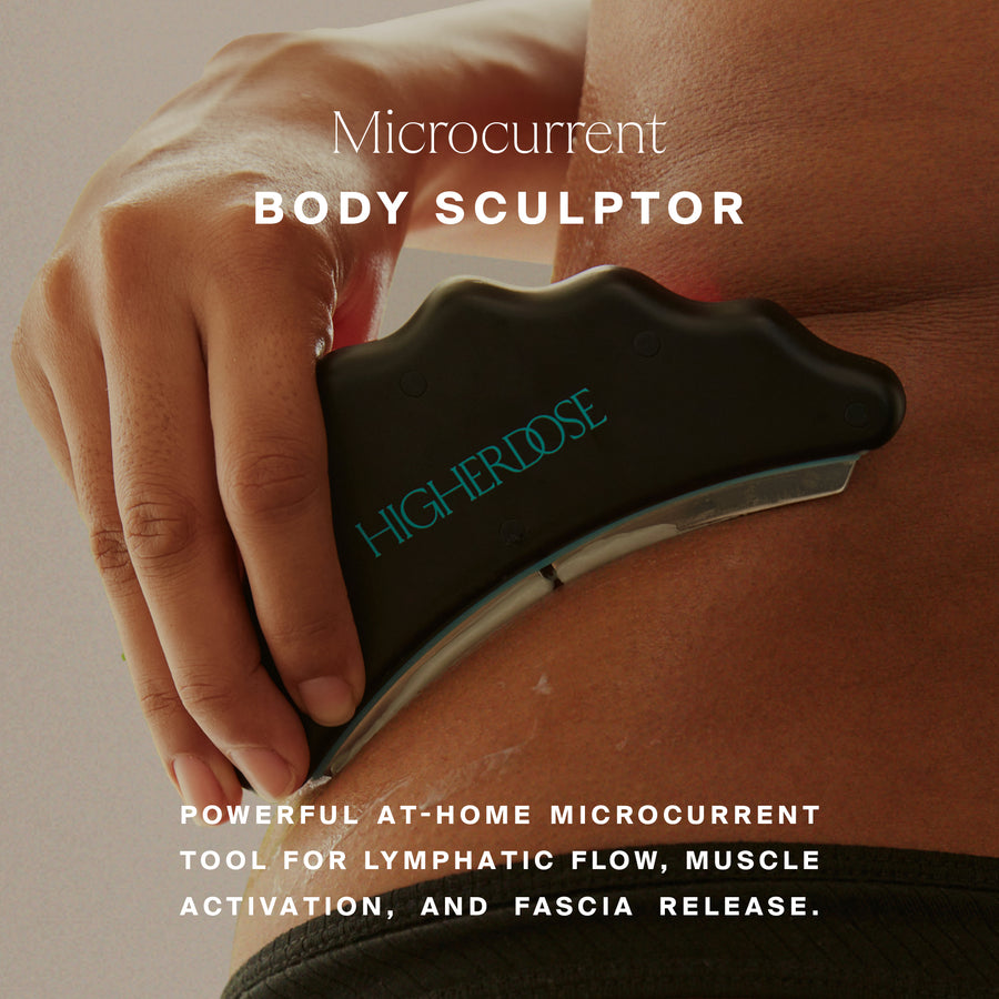 Hand holding black microcurrent body sculptor device with curved ergonomic design and 