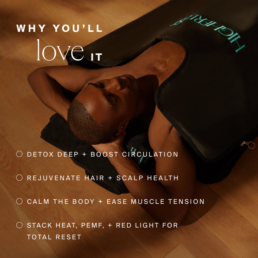 Man lying on wooden floor wearing black therapeutic wrap around head and shoulders.