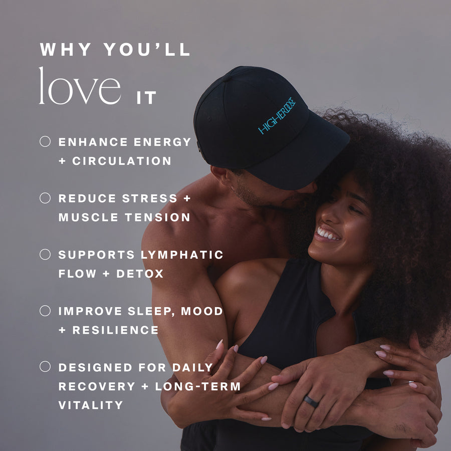 Two people embracing, one wearing a black baseball cap with teal text and black shirt.