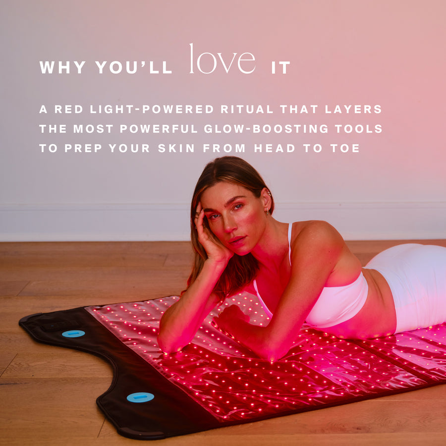 Woman reclining on red light therapy mat with pink exercise ball on wooden floor.