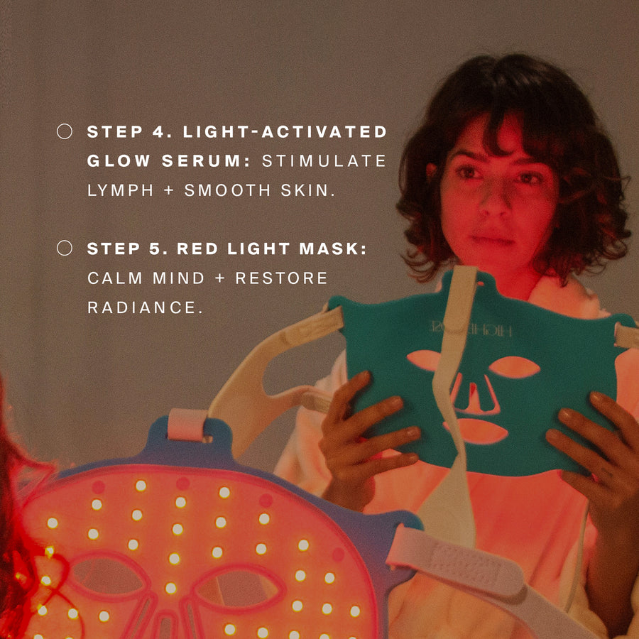Person holding a green face mask and red light therapy device under red lighting.