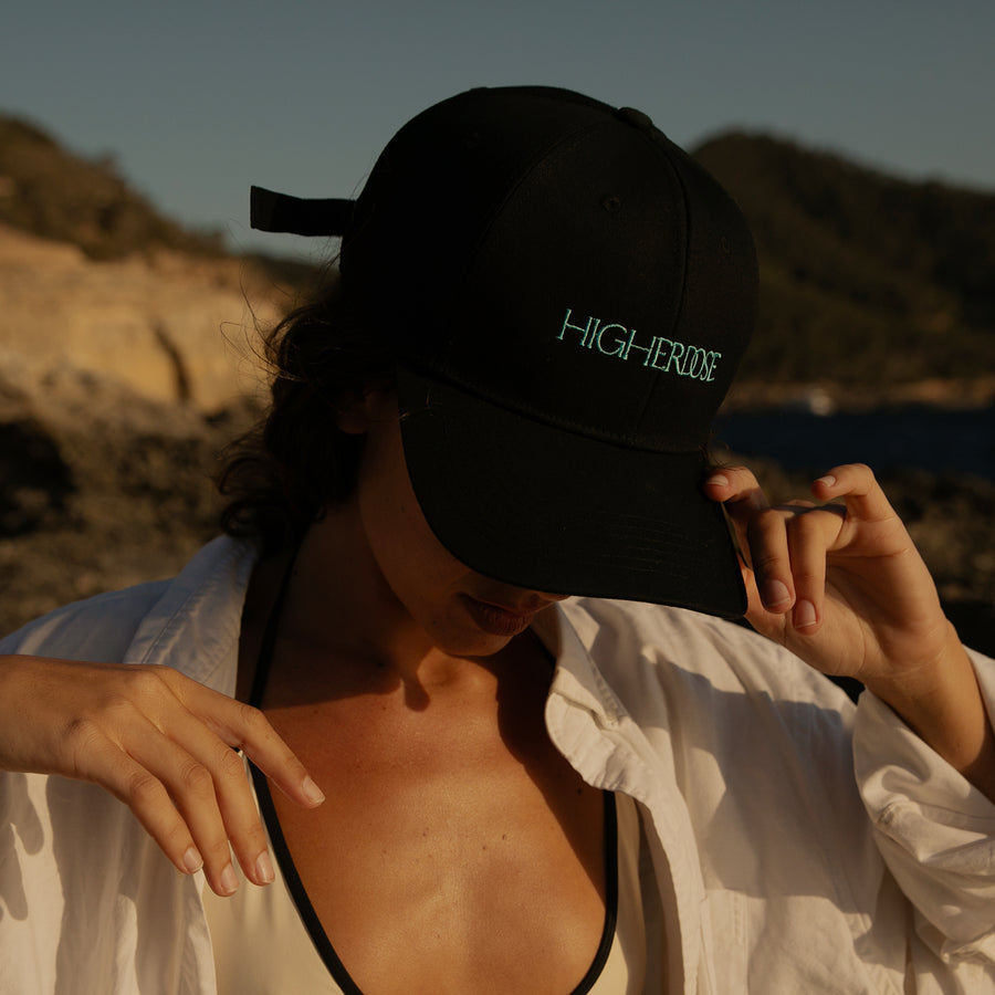 Person wearing black baseball cap with 