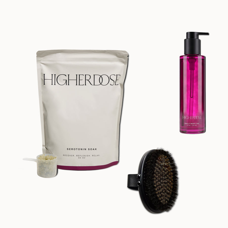Higher Dose serotonin soak bath package, daily body oil pump bottle, and black dry brush.