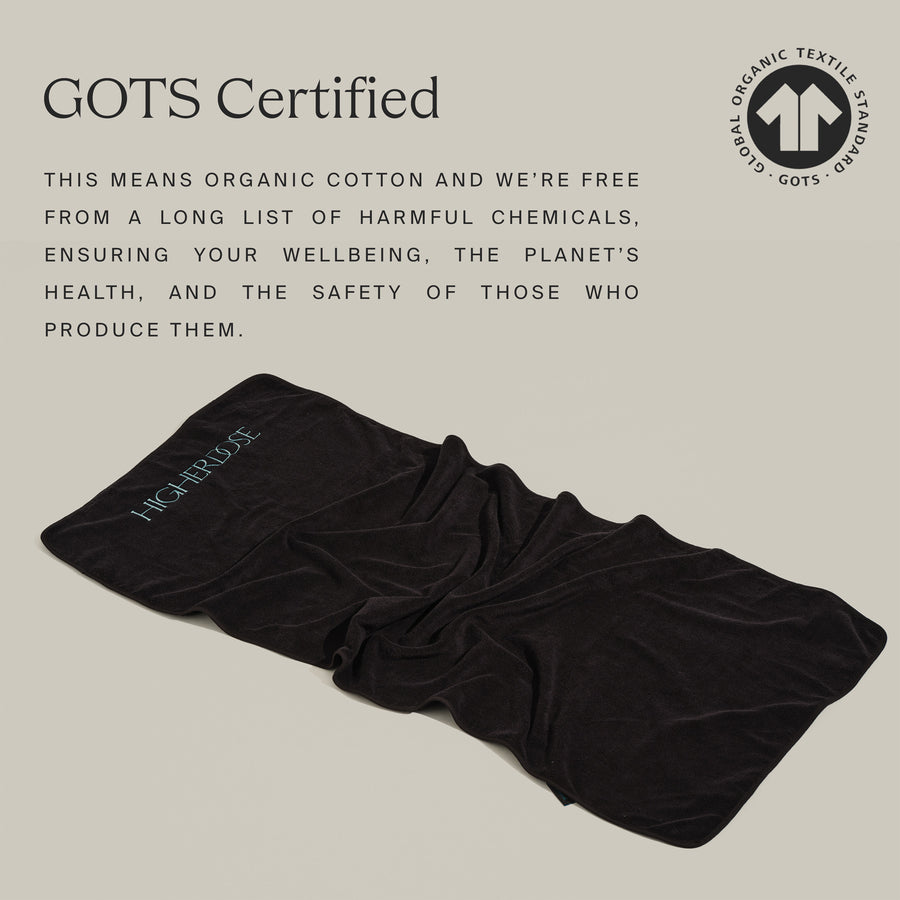 Black organic cotton PEMF mat cover with GOTS certification logo and text detailing chemical-free production standards.
