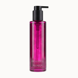 Clear bottle with black pump dispenser containing magenta-colored body oil, labeled 