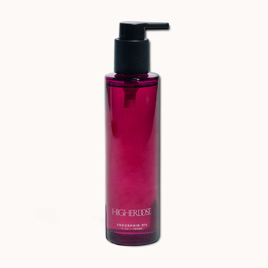 Cylindrical pump bottle with deep magenta liquid, black pump dispenser, and white text label reading 