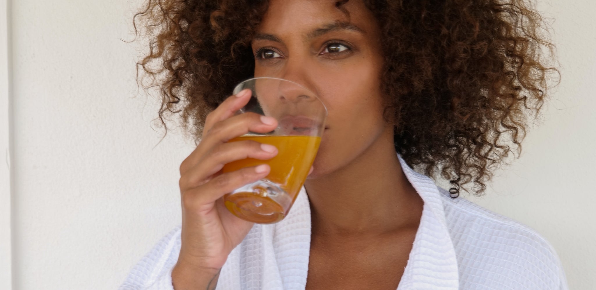 A woman drinking an orange beverage