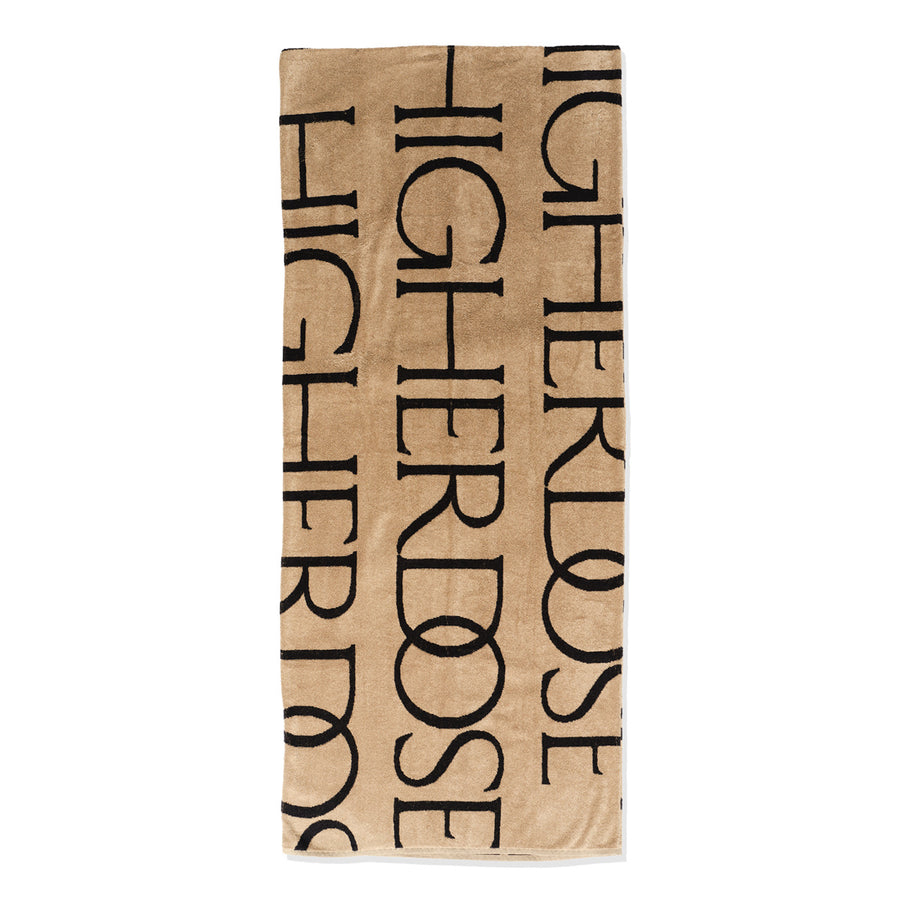 Rectangular blanket with tan fabric and repeated black text reading 