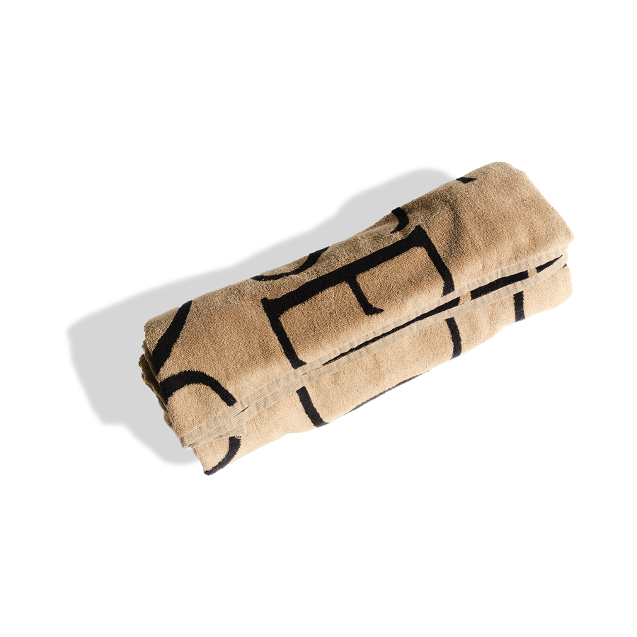 Tan and black fabric blanket insert rolled up, showing woven textile pattern and internal straps.