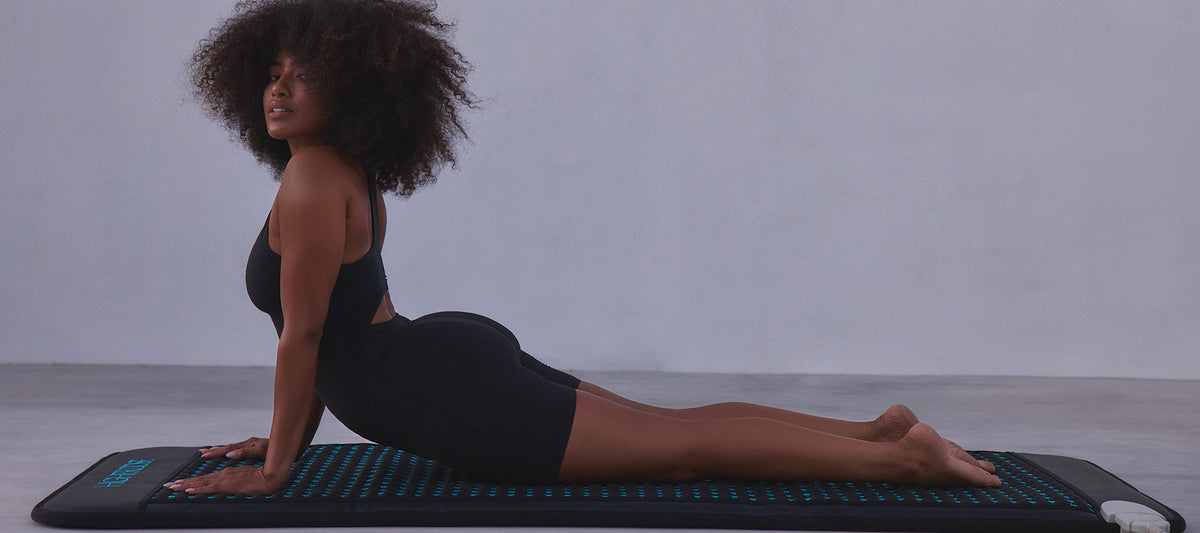 Woman practicing yoga on a mat with a neutral background