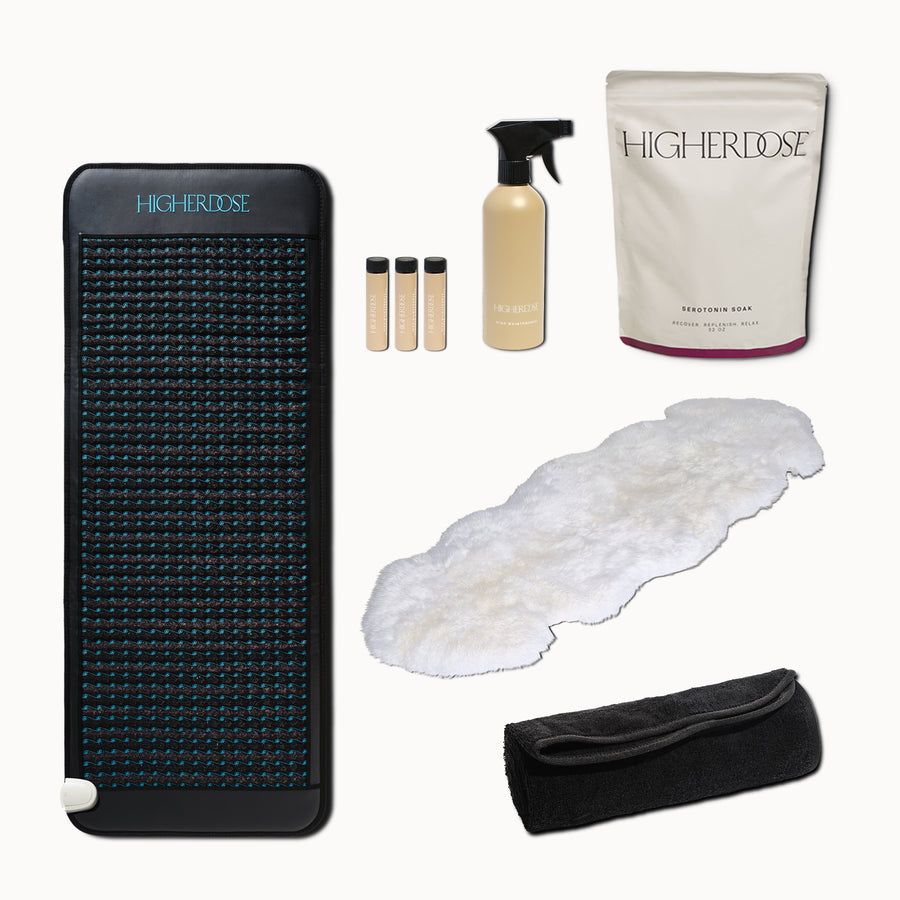 Black PEMF mat with blue dots, spray bottle, three vials, white towel, cream pouch, white fleece pad, and black carrying bag.