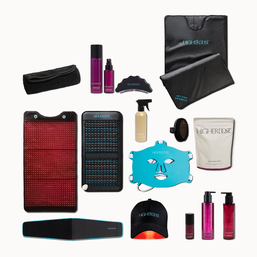 Collection of wellness and beauty products including light therapy panels, skincare bottles, facial mask, spray bottle, brush