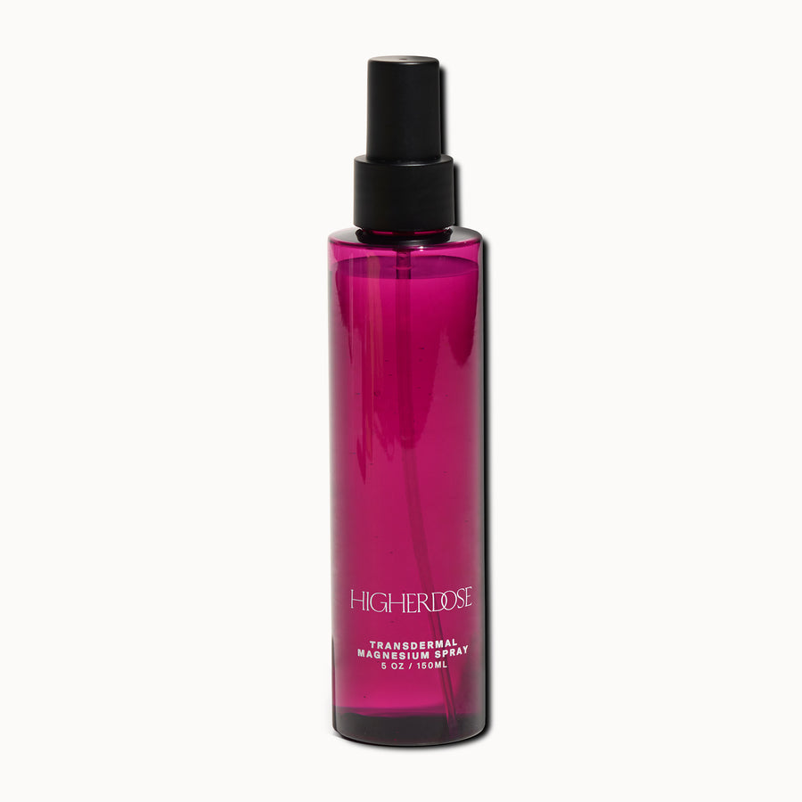 Magenta spray bottle with black pump top and label reading 