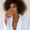 A woman drinking an orange beverage
